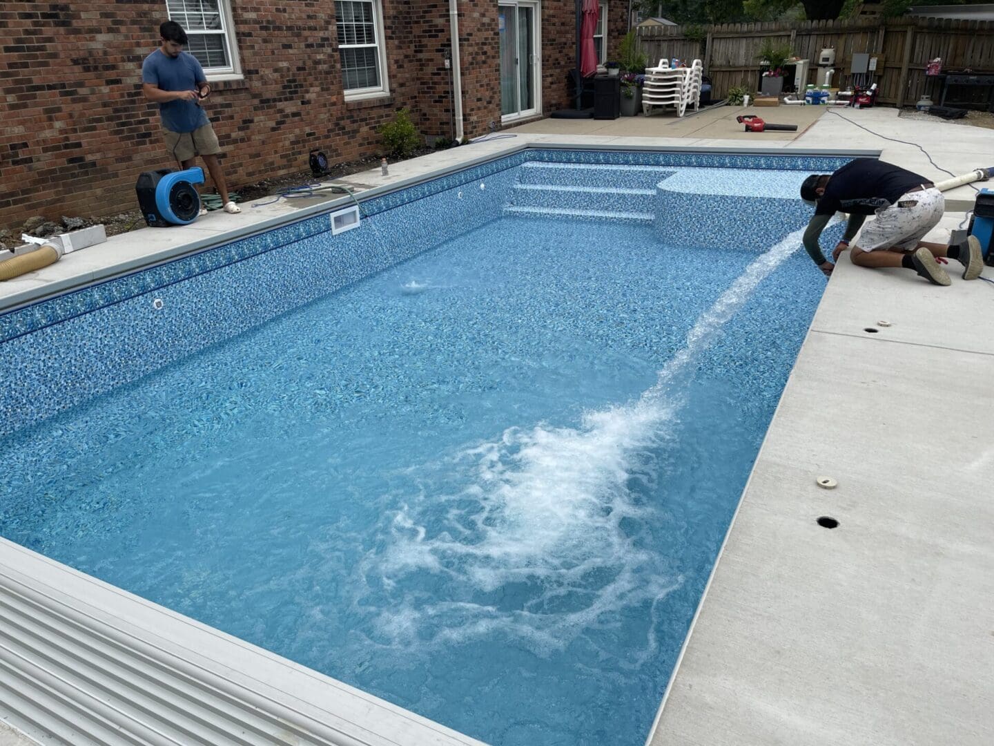 A person is spraying water into the pool.