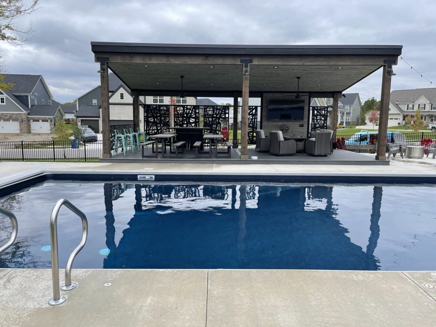 A pool with an awning over it and some chairs