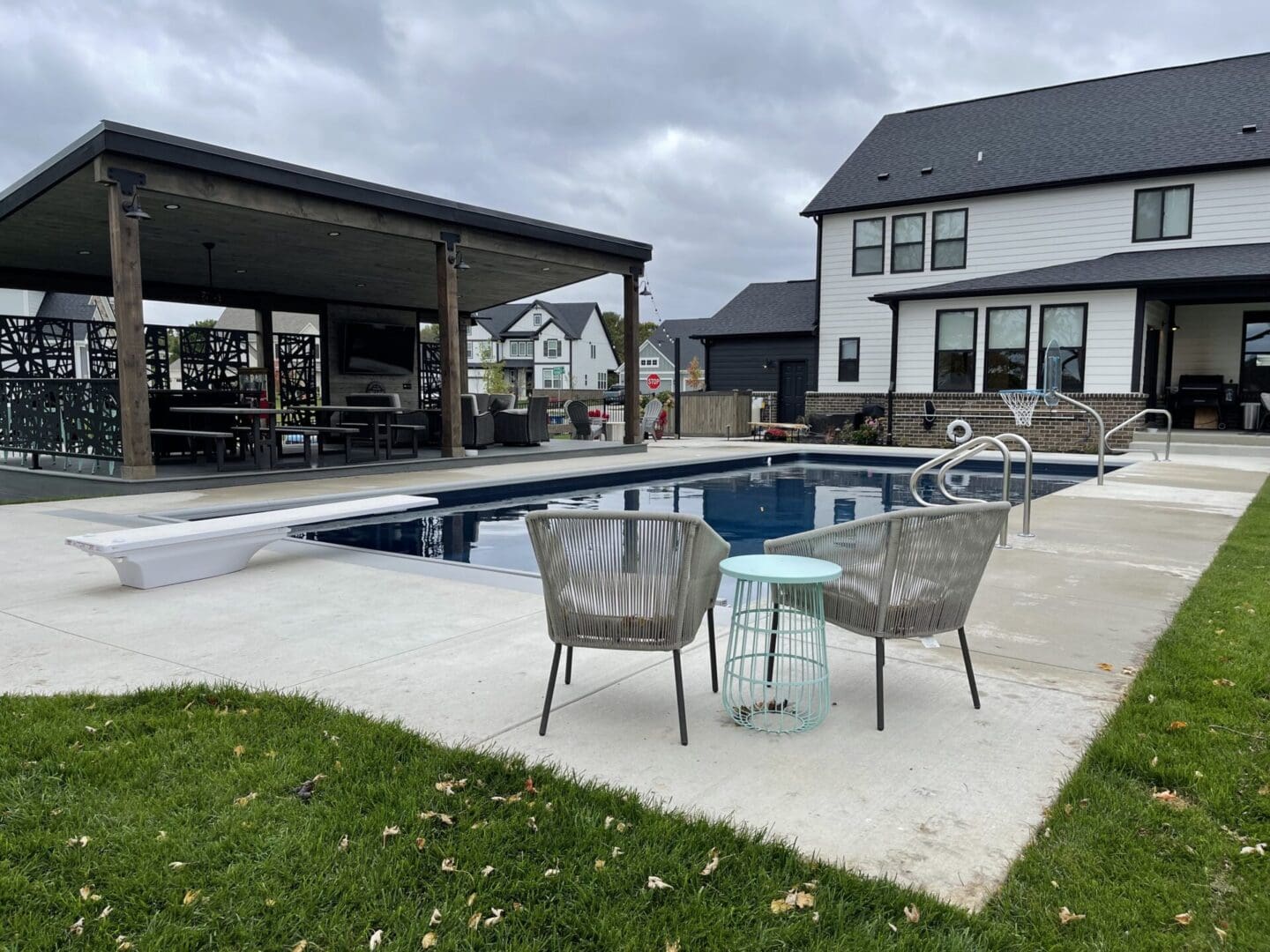 A pool with two chairs and tables in the middle of it