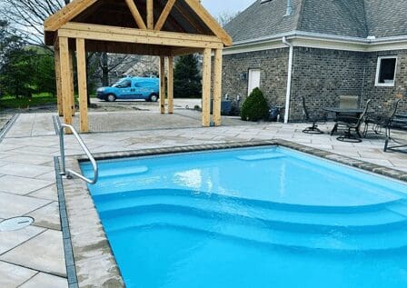 A pool with a wooden structure in the background.