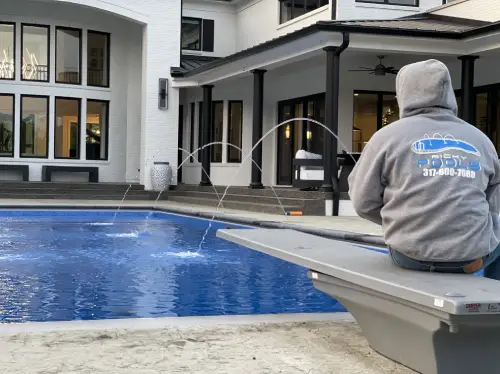 A person sitting on the edge of a pool