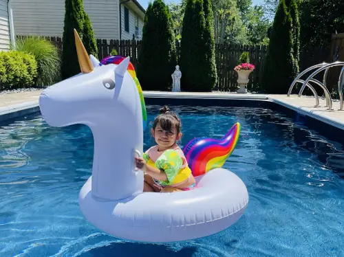 A baby sitting on top of an inflatable unicorn.